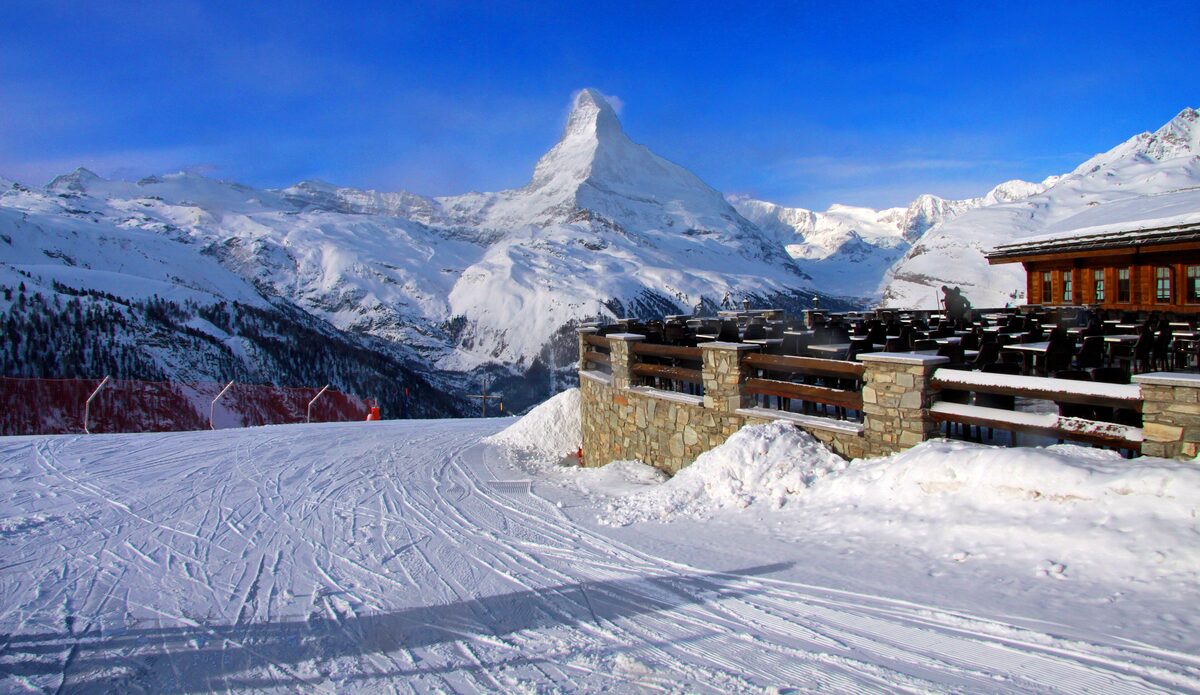 The Matterhorn above snowy pistes and the terrace of a mountain restaurant at Sunnegga