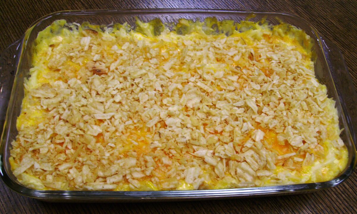 A glass baking dish of funeral potatoes with a crunchy topping