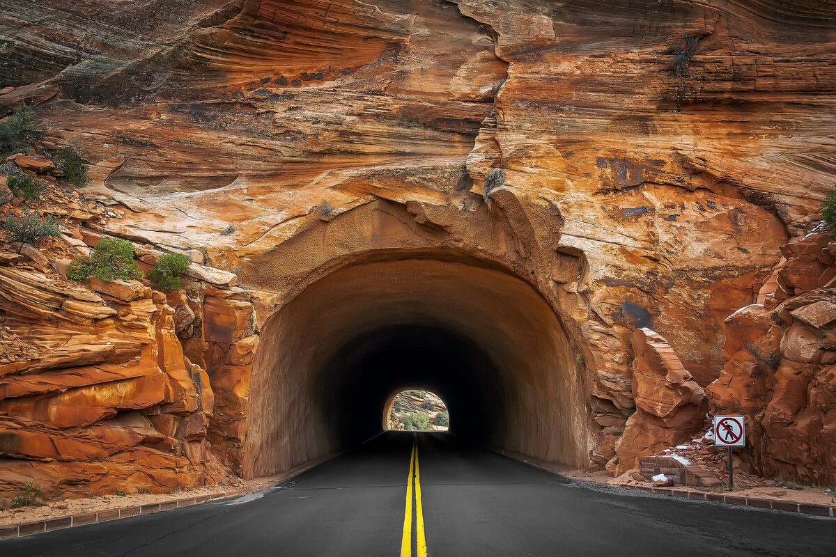Tunnel cut through layered orange sandstone on the Zion-Mount Carmel Highway