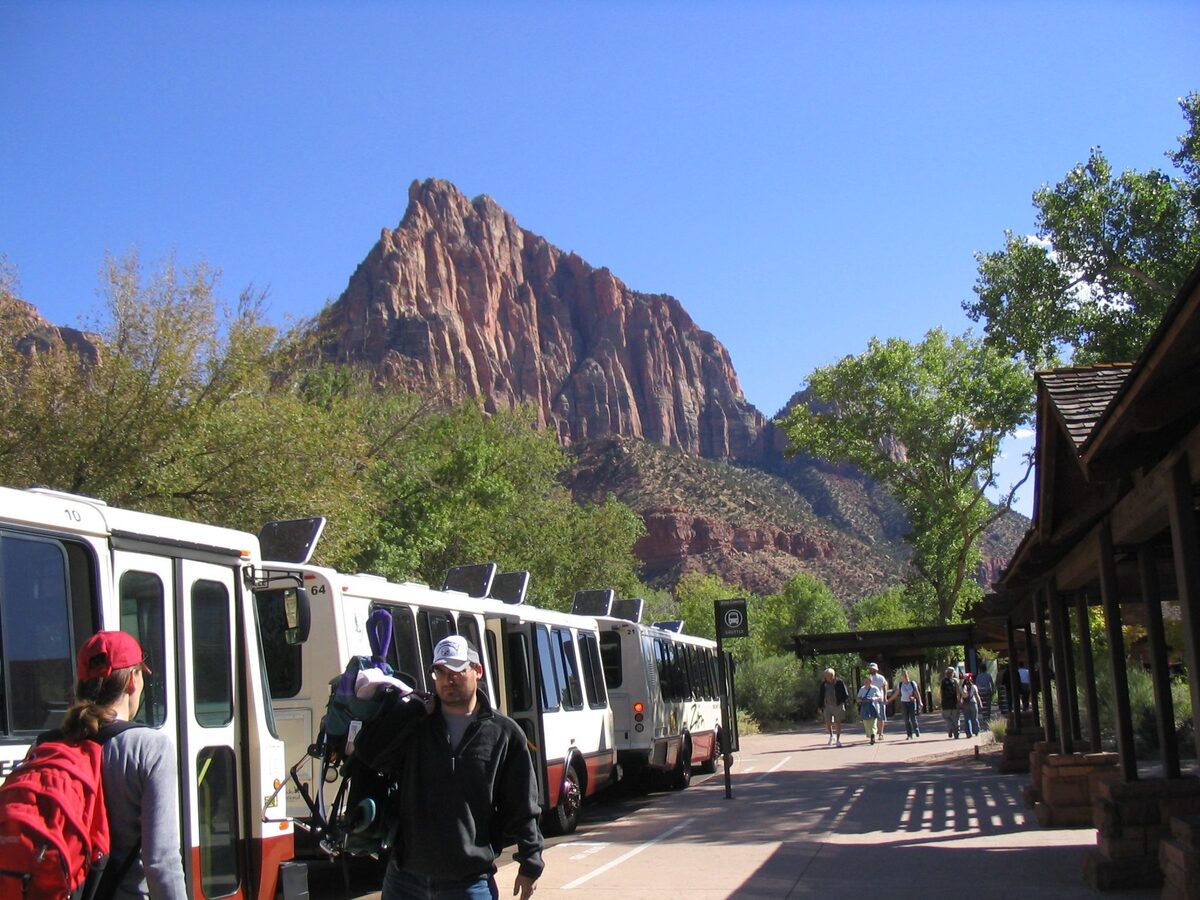 Zion shuttle buses lined up beneath the Watchman at the visitor center