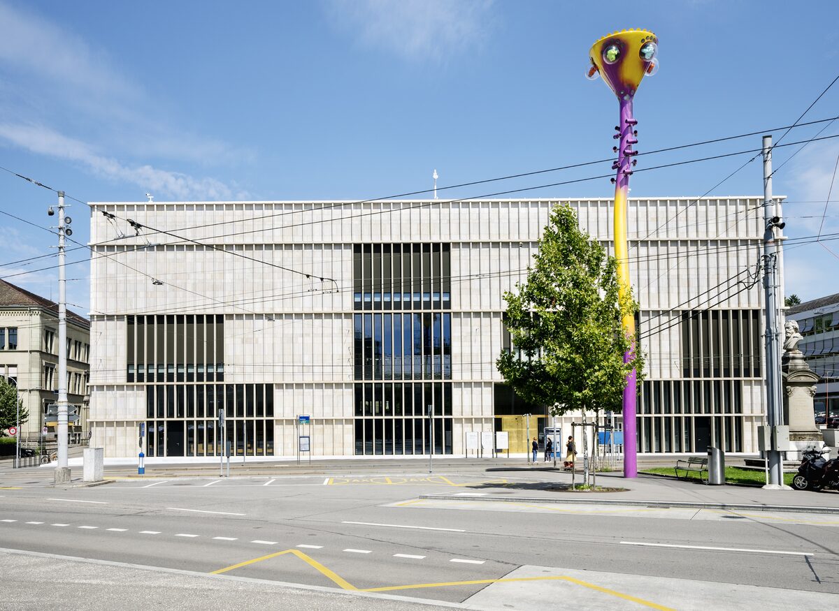 The pale stone Chipperfield extension of the Kunsthaus on Heimplatz, with a tall colorful sculpture in front of the facade