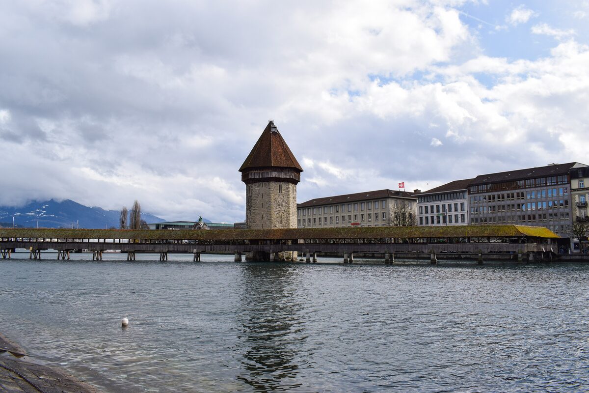 The covered Chapel Bridge and the Water Tower on the Reuss in Lucerne, with the lake and mountains behind